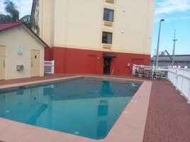 Una piscina al aire libre, sillones reclinables de piscina