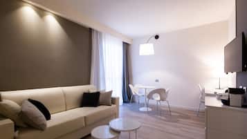 Una sala moderna con un sofá, dos mesitas y un comedor con sillas.