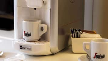 Una cafetera con un portavasos y una caja de tazas de café.