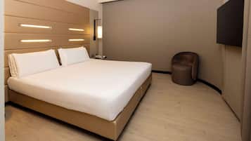 Een moderne hotelkamer met een groot bed, nachtkastjes, een flatscreen televisie en een prullenbak.