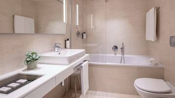 A modern bathroom with a glass-enclosed shower, a white sink, and a toilet.