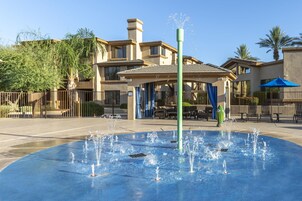 Una fuente de agua en un patio con un edificio al fondo.