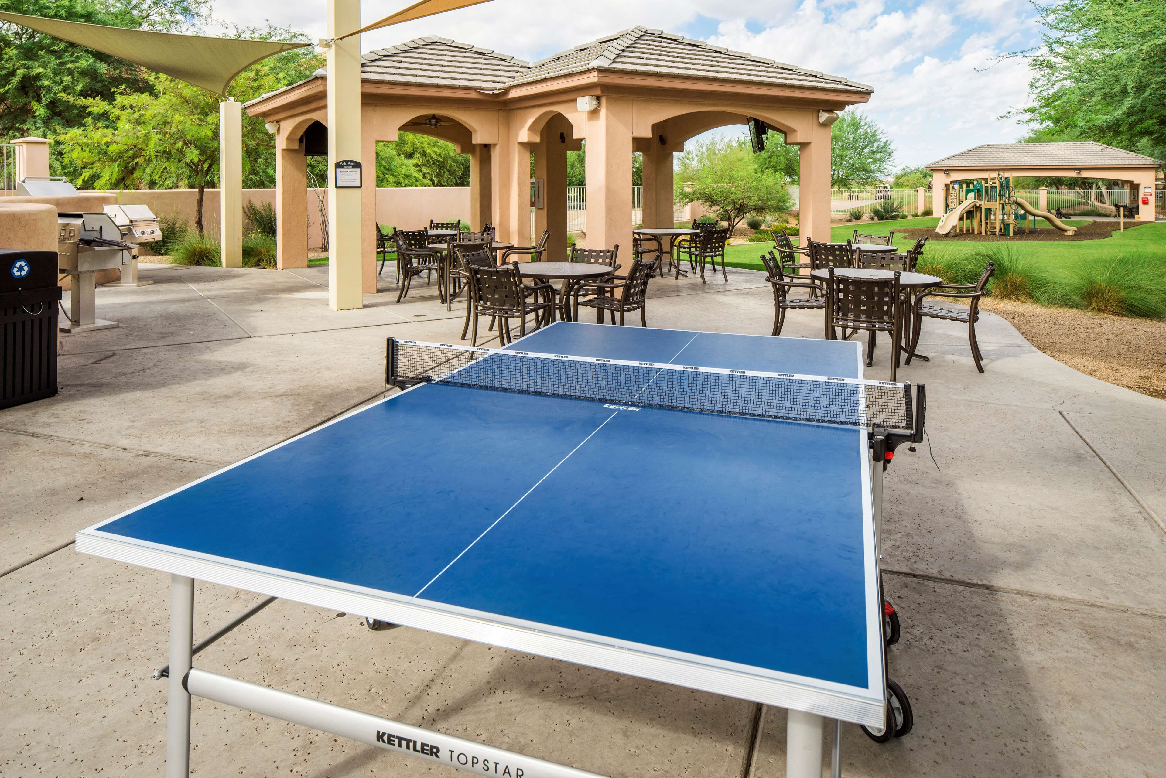Une table de ping-pong extérieure dotée d’un auvent et d’un espace détente.