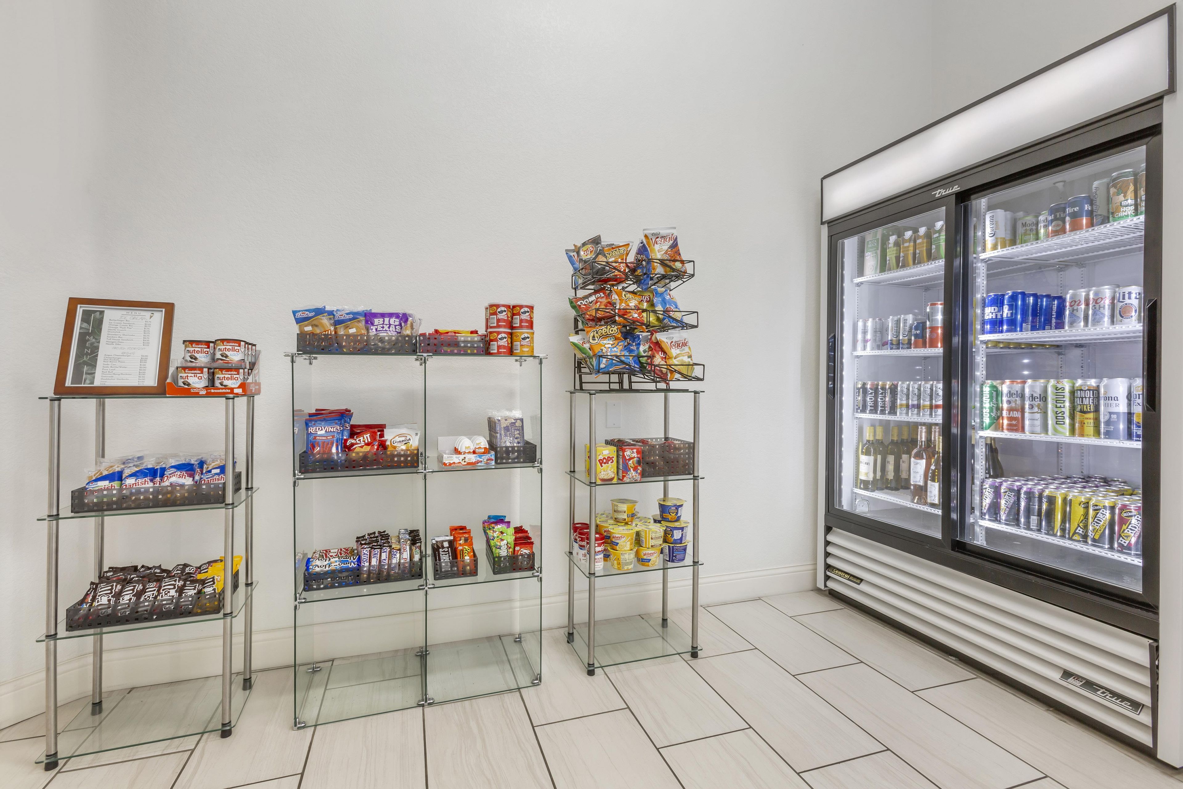 A snack and beverage display area with various packaged goods and a refrigerated section.