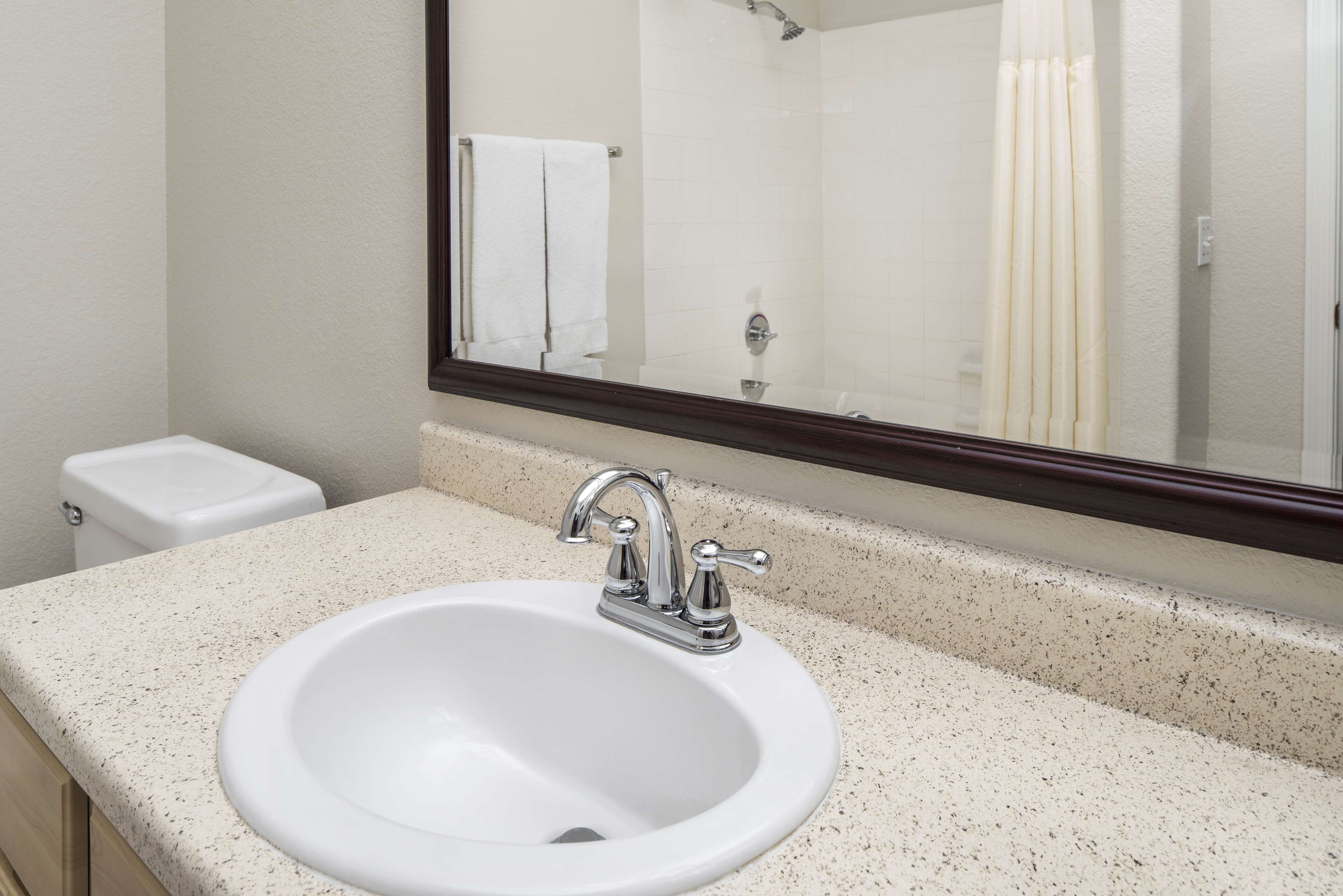 Une salle de bain avec un lavabo blanc, un miroir et une douche.