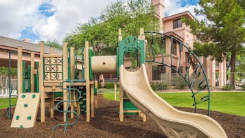 A playground with a slide, climbing structures, and a ball pit.