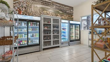 Un présentoir réfrigéré pour boissons dans un magasin, où sont exposées diverses boissons et collations.