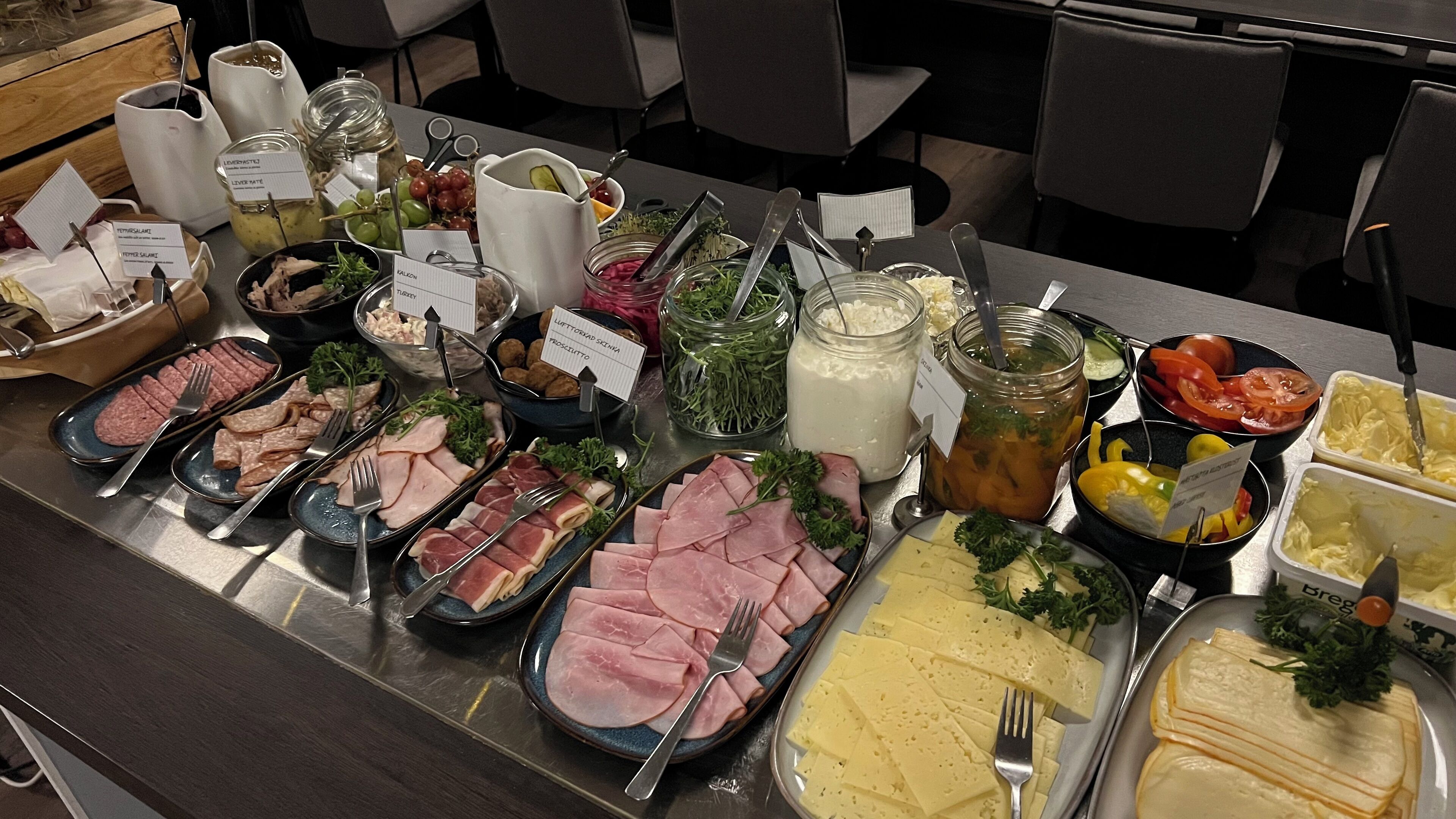 A buffet with various food options including meats, cheeses, and salads.