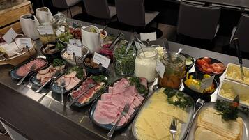 A buffet with various food options including meats, cheeses, and salads.