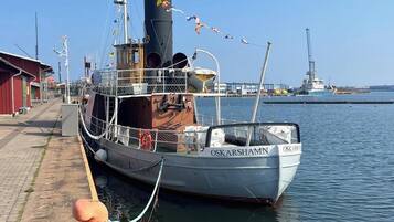 A docked boat named "OSKARSHAMN" with a metal railing and a cabin structure.