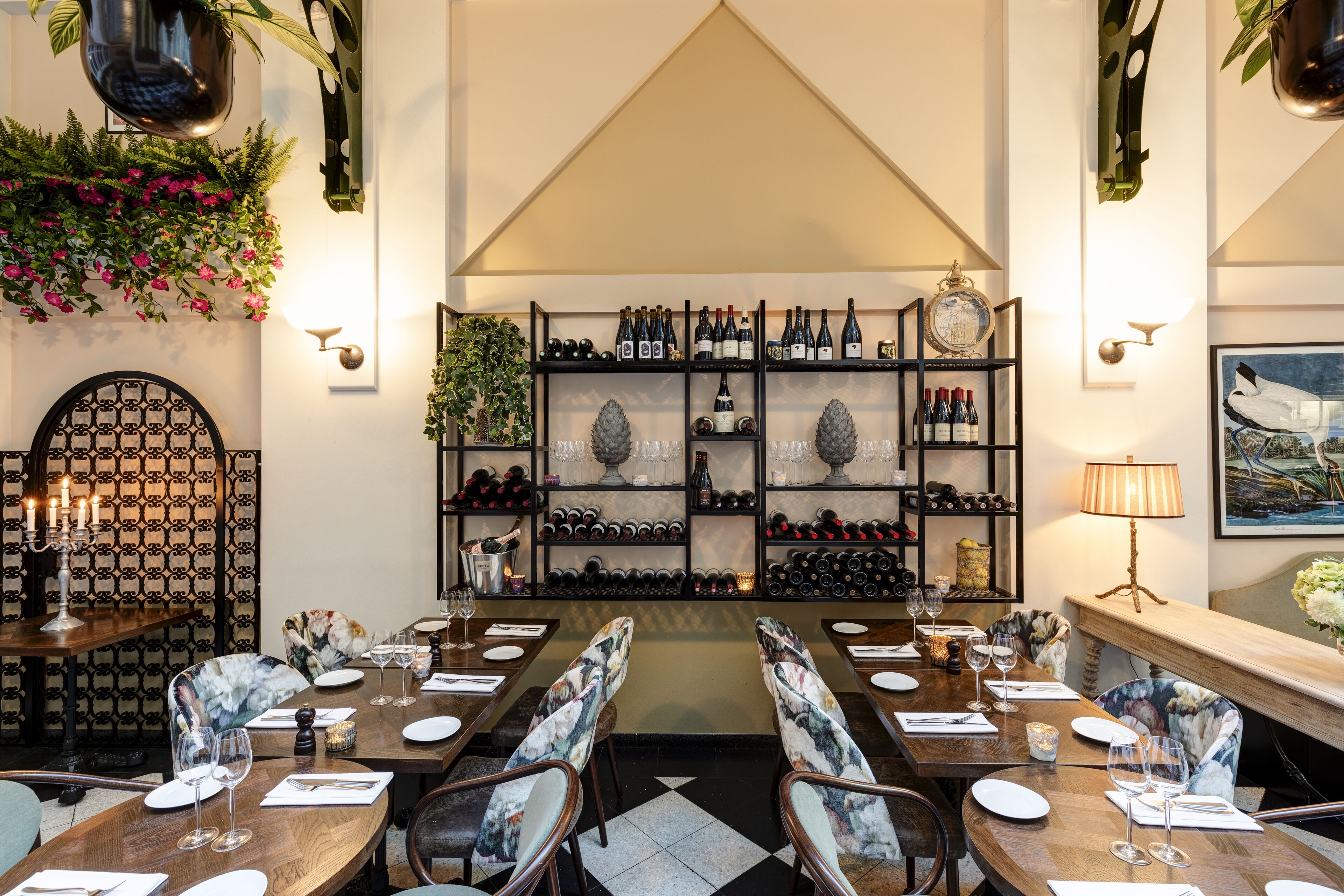 A restaurant with a wine cellar, wooden tables, and chairs.