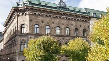 Un edificio storico con tetto verde, ampie finestre e un'antenna.