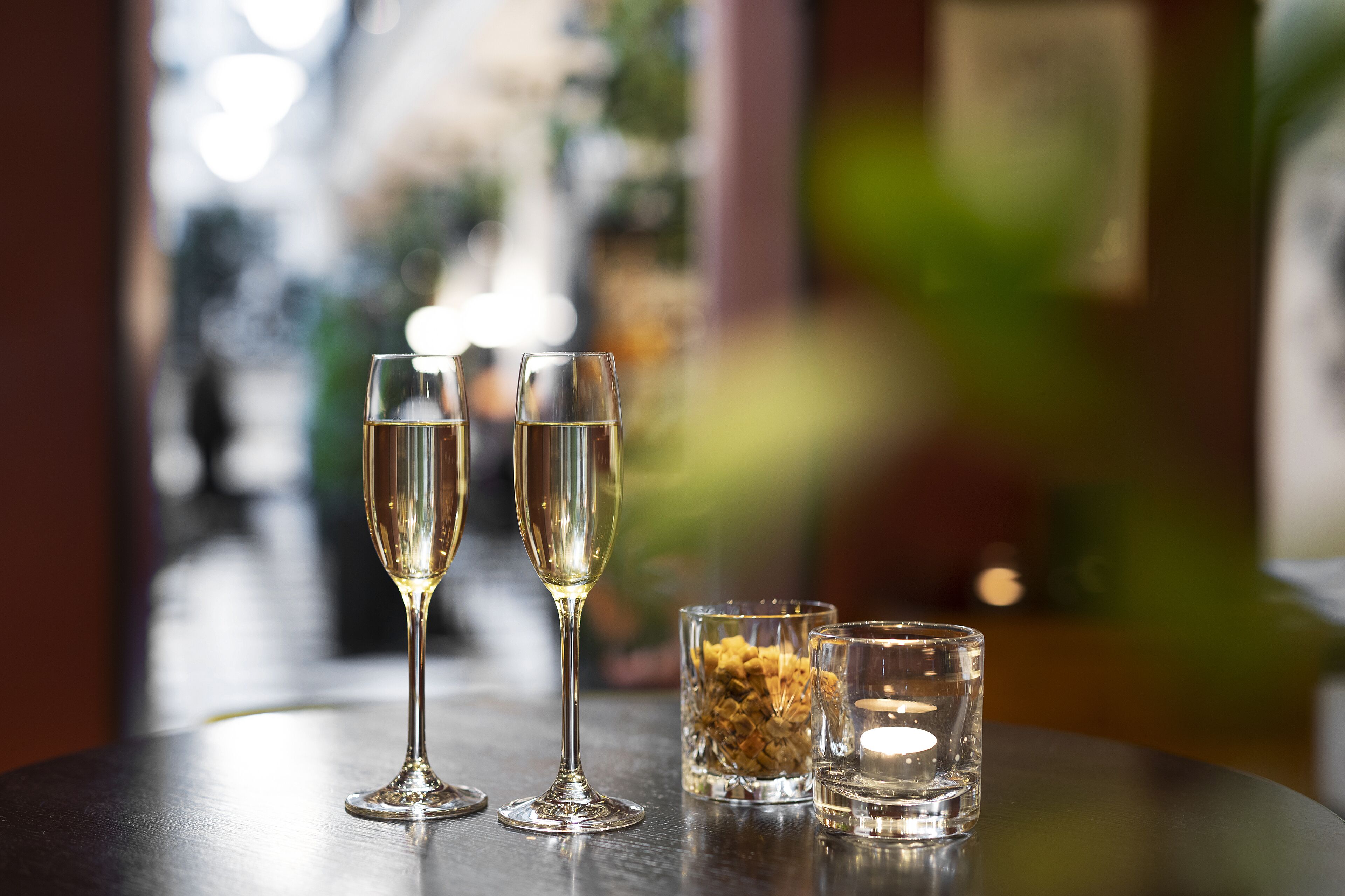 Dos copas de champán y dos vasos pequeños sobre una mesa.