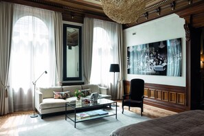 Habitación bien iluminada con un espejo grande, un sofá, una mesa de centro y un cuadro en la pared.