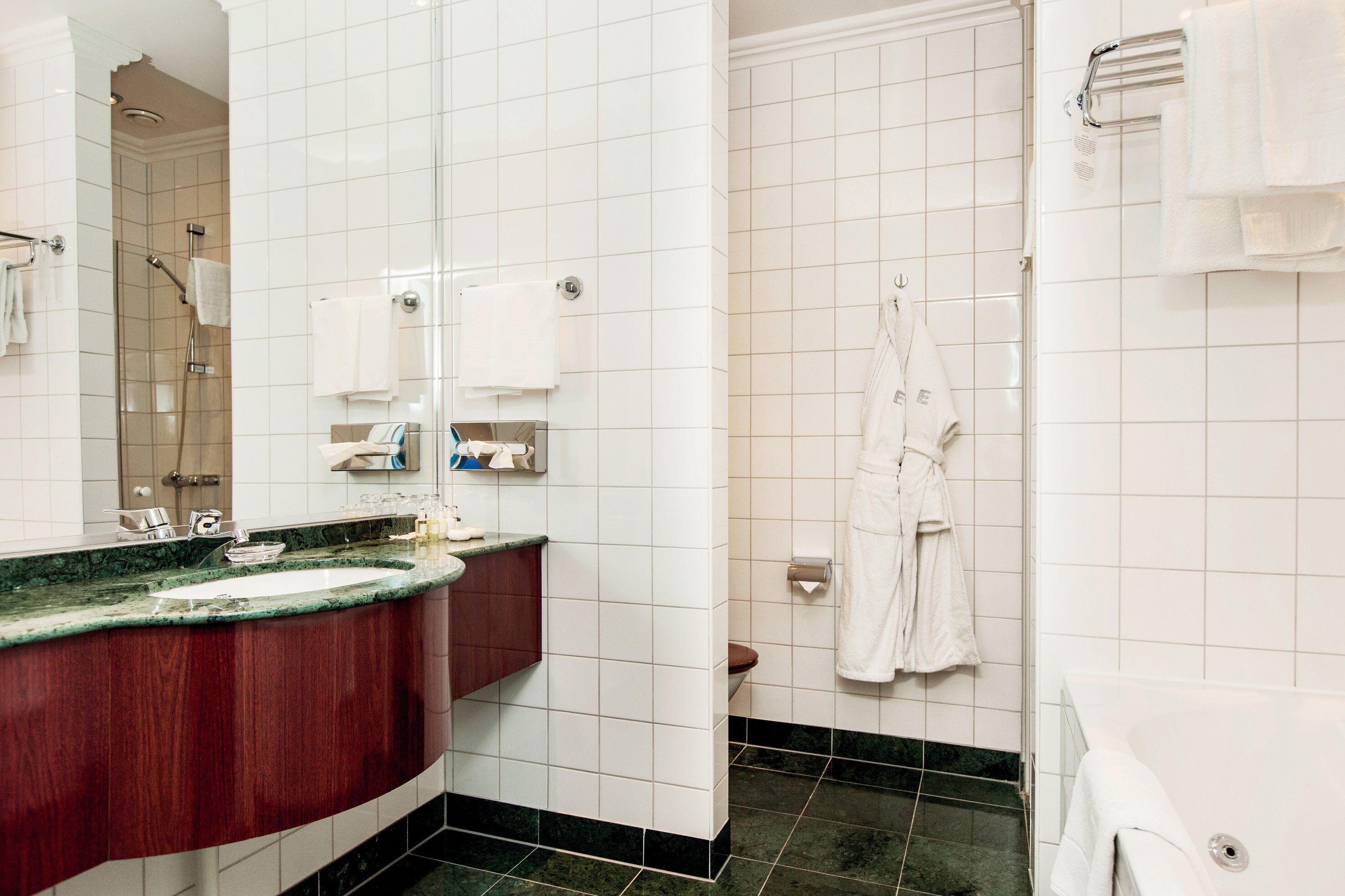A modern bathroom with a marble sink, a shower, and a bathtub.