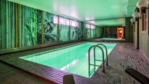 Una piscina con piso de baldosas y escalera de metal.