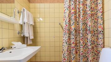 A bathroom with a shower curtain, a sink, and a toilet.