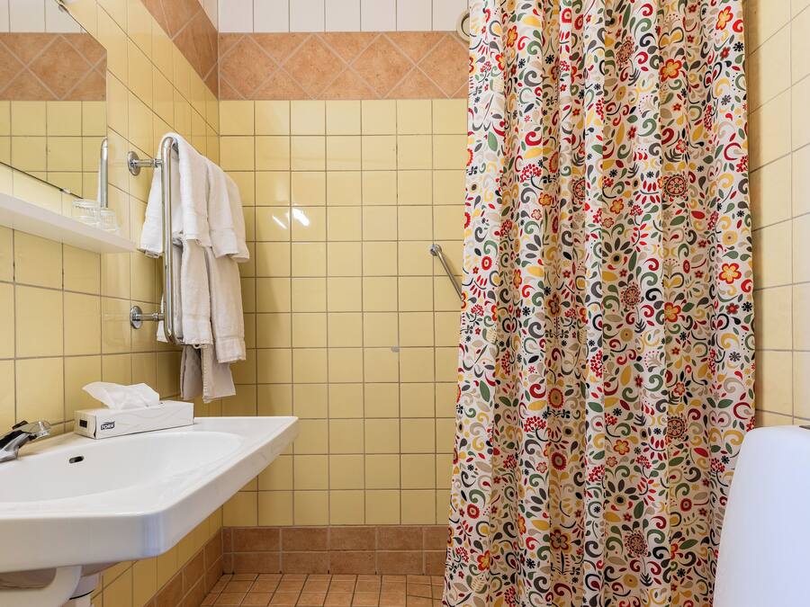 A bathroom with a shower curtain, a sink, and a toilet.