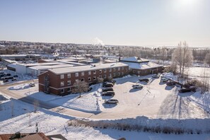 A large building with multiple parking lots and a clear sky. - Hotel Kung Gösta (Mora)
