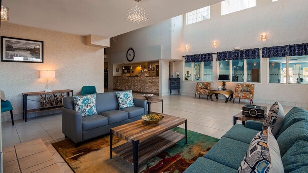 A spacious living area with a sofa, coffee table, and a view of the kitchen. - Best Western Plus Liberty Lake Inn (Liberty Lake)