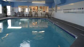 Una piscina techada, sillones reclinables de piscina