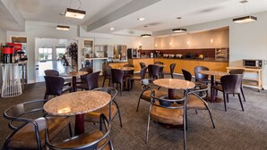 A modern cafe with round tables and chairs, a bar area, and a visible kitchen. - Best Western Plus Liberty Lake Inn (Liberty Lake)
