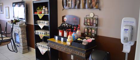 A kitchen area with a coffee station, a fish-themed wall decoration, and a hand sanitizer dispenser.