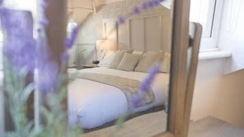 A bedroom with a bed, nightstand, lamp, and window.