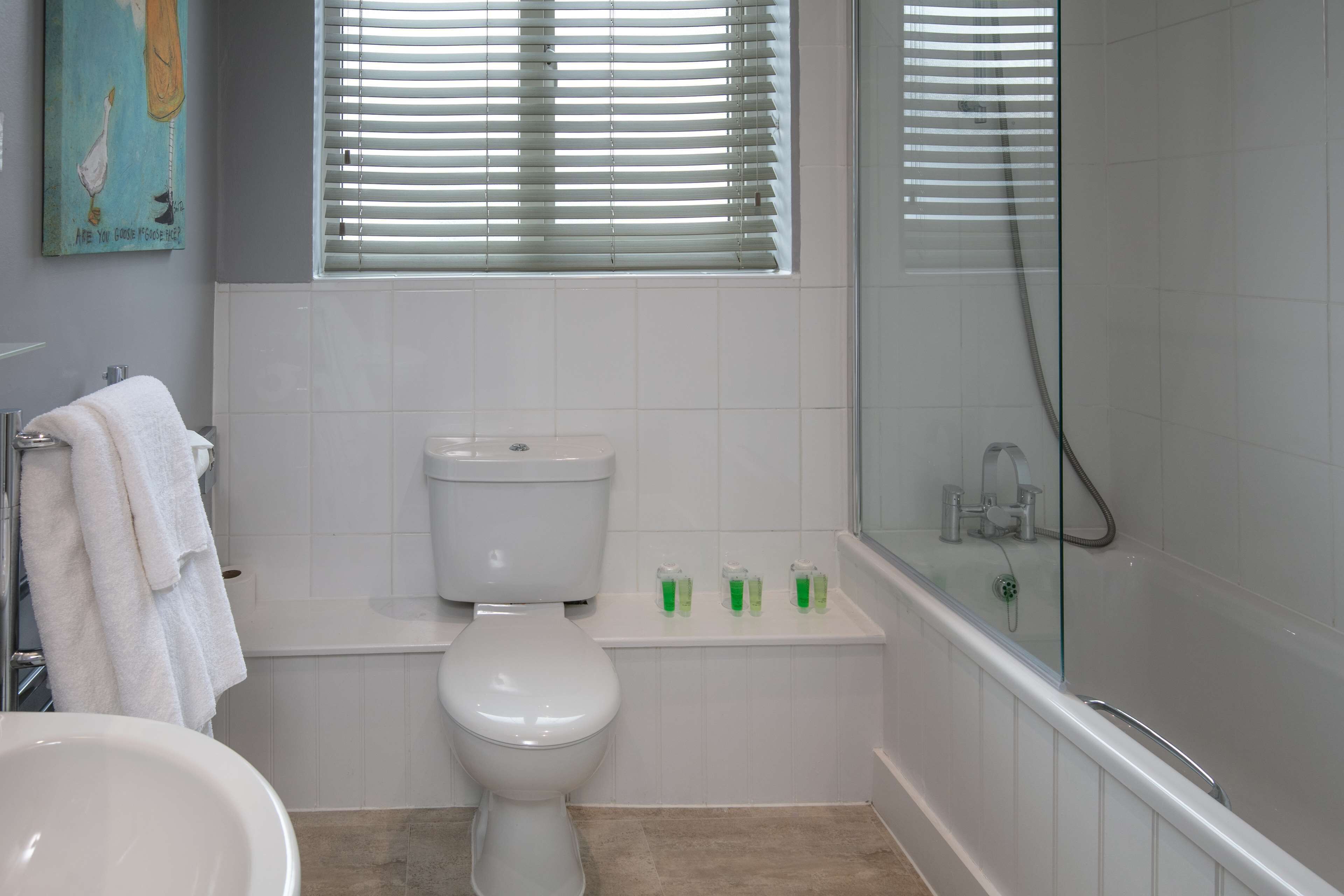 Een badkamer met toilet, wastafel en bad.