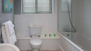 Een badkamer met toilet, wastafel en bad.