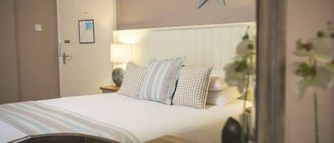 A neatly made bed with striped bedding, a star decoration on the wall, and a bedside lamp.