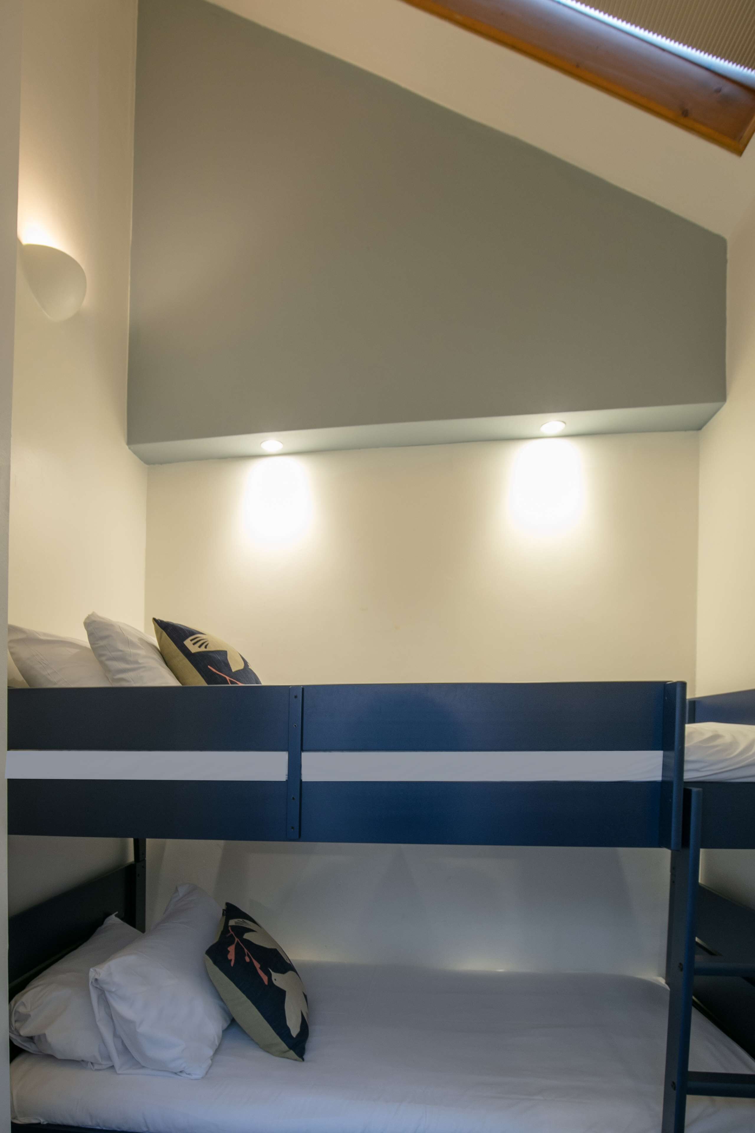 A bunk bed with two pillows and a decorative pillow on the lower bunk.