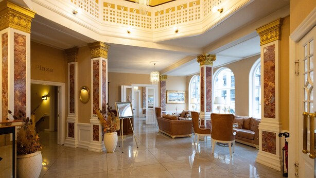 A spacious lobby with a high ceiling, marble flooring, and classic furnishings including sofas and chairs. - Milling Hotel Plaza (Odense)