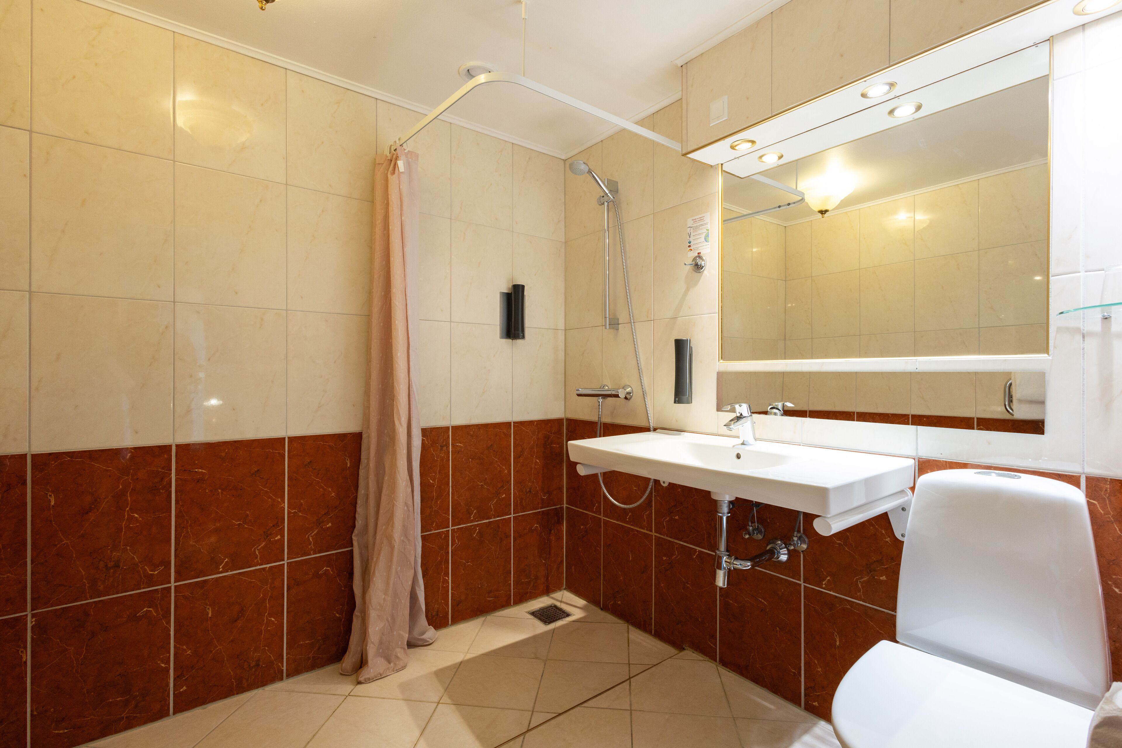 A bathroom with a shower, sink, and toilet.