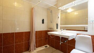A bathroom with a shower, sink, and toilet.