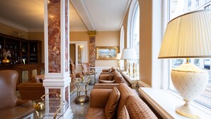 A luxurious living room with a sofa, armchairs, a glass coffee table, and a lamp. - Milling Hotel Plaza (Odense)