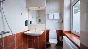 Un baño moderno con ducha, lavamanos e inodoro.