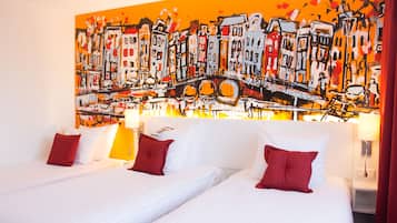 A hotel room with two beds, white bedding, red pillows, and a large abstract painting on the wall.