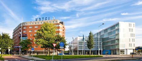 A hotel with a curved facade, a bike lane, and a pedestrian crossing.