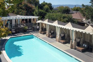 A swimming pool with a covered seating area and a view of the surrounding landscape. - Aloft by Marriott San Jose Cupertino (San Jose)