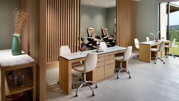 A modern office with a large desk, chairs, and a view of the outdoors.