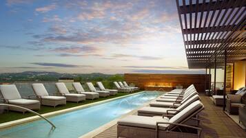 Unwind by the rooftop infinity pool, taking in the serene city and hill views.