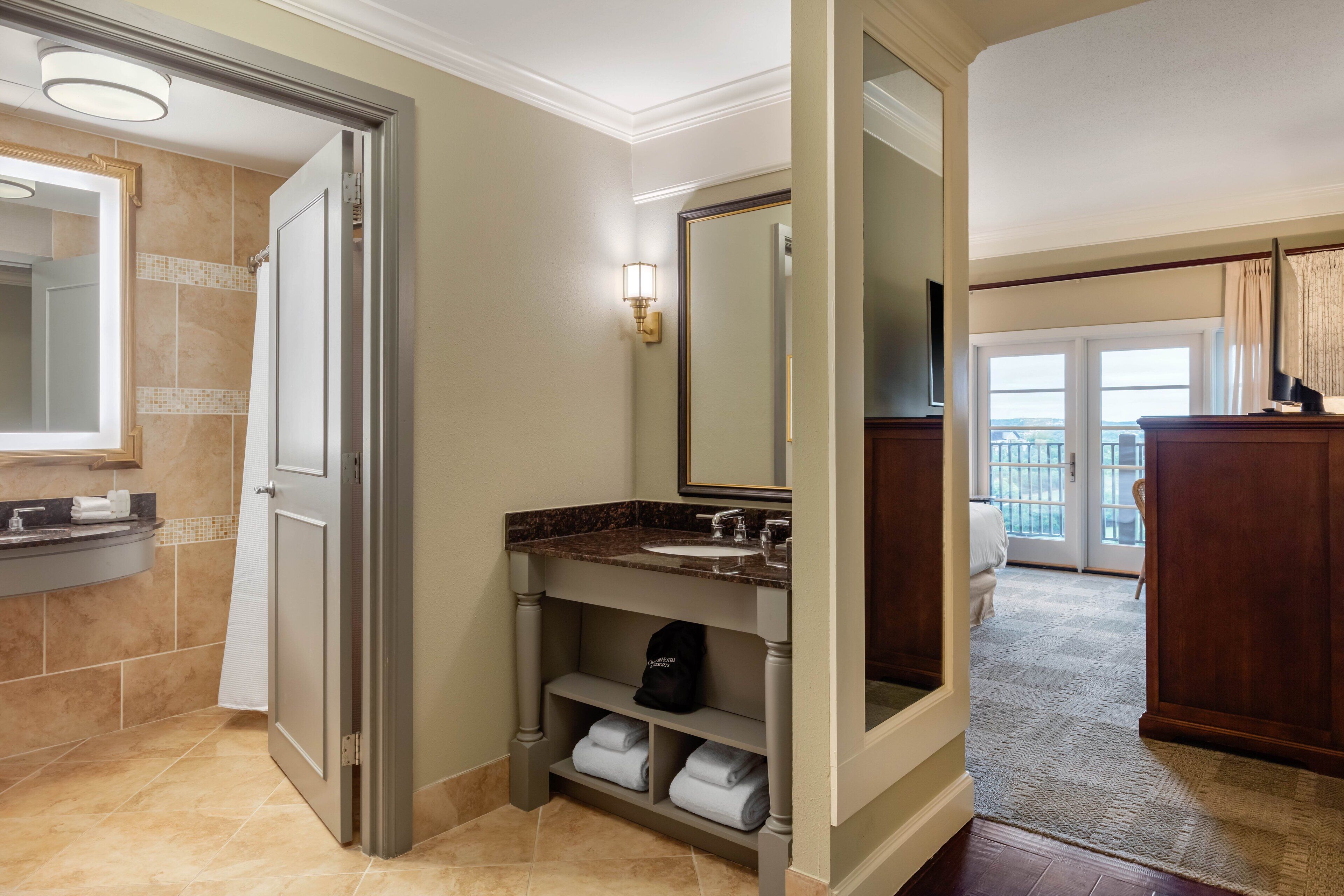 Een moderne badkamer met een marmeren wastafel, een grote spiegel en een ruime douche.