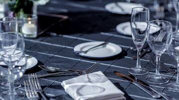 Mesa servida con platos, cubiertos y vasos, lo que sugiere una disposición para cenar formal.