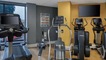 A gym with treadmills, elliptical machines, and a stationary bike.