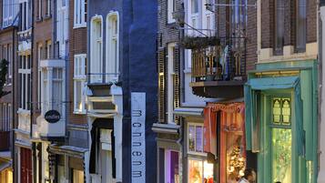 Een rij traditionele Europese gebouwen met winkelgevels, waarvan sommige borden hebben.