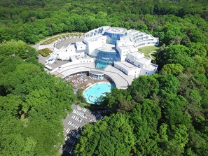 An aerial view of a resort with a swimming pool, multiple buildings, and lush greenery surrounding it. - Sanadome Hotel & Spa Nijmegen (Nijmegen)