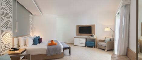 Une chambre d’hôtel moderne équipée d’un lit, d’un bureau, d’un canapé, d’une télévision et d’une chaise.