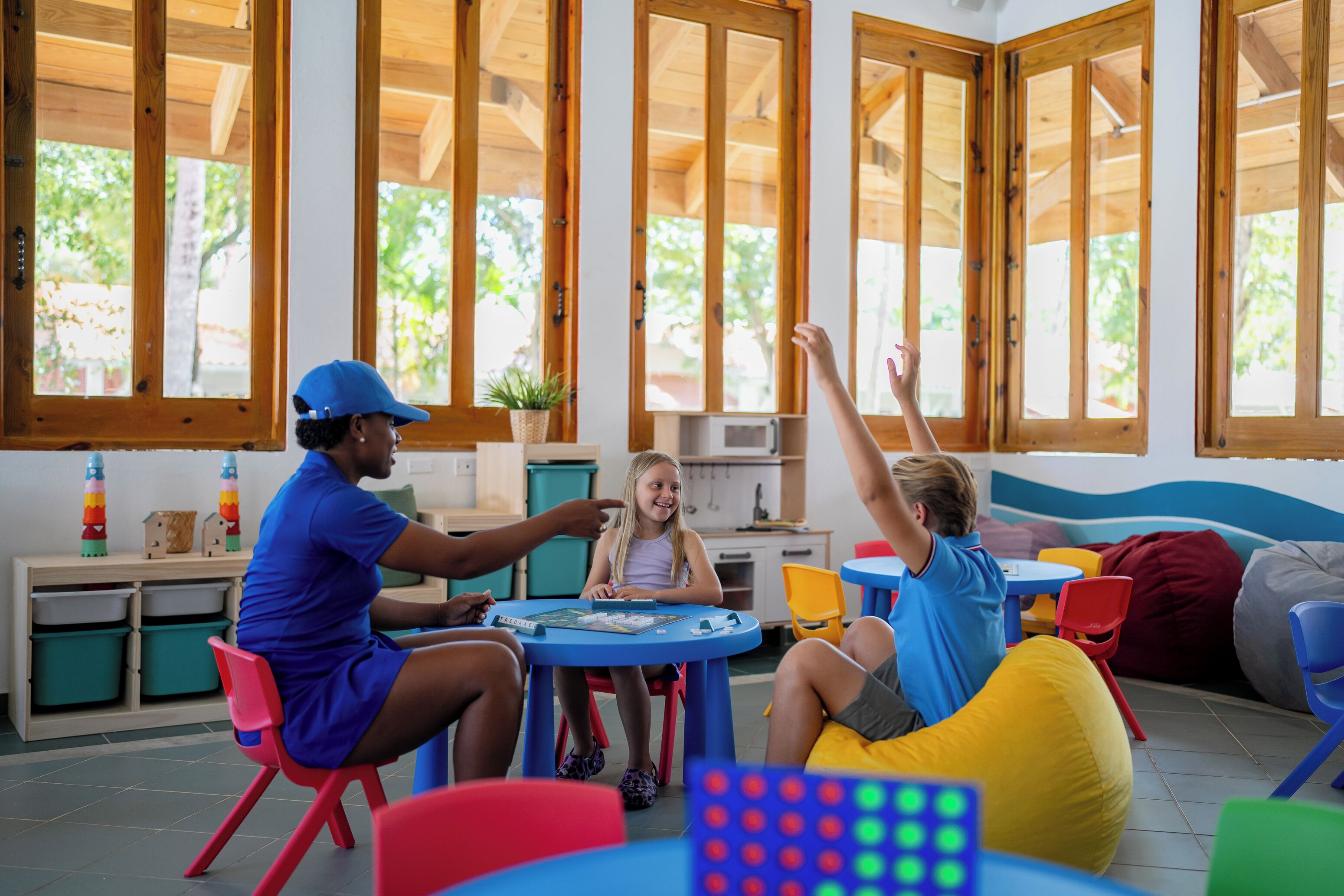 A room with large windows, wooden beams, and colorful furniture.