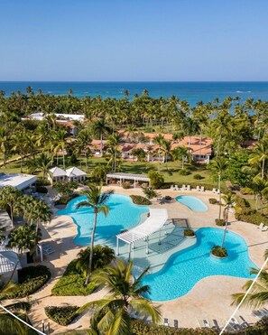 A resort with multiple swimming pools, palm trees, and a view of the ocean. - Wyndham Alltra Samana All-Inclusive Resort (Las Galeras)